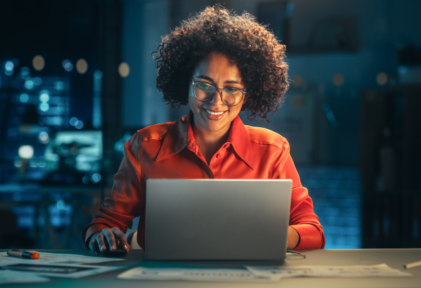 Woman in orange shirt at computer.